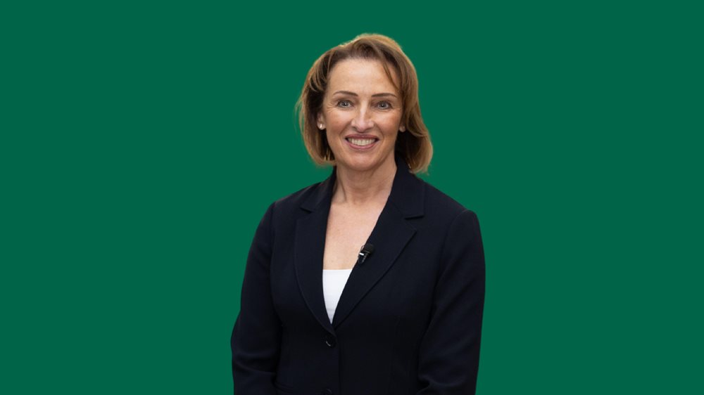 Sarah Pochin, MP for Runcorn and Helsby, against a green background