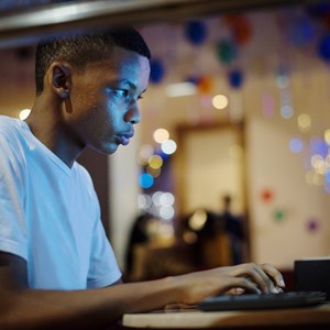 A teenage boy stares at a computer screen